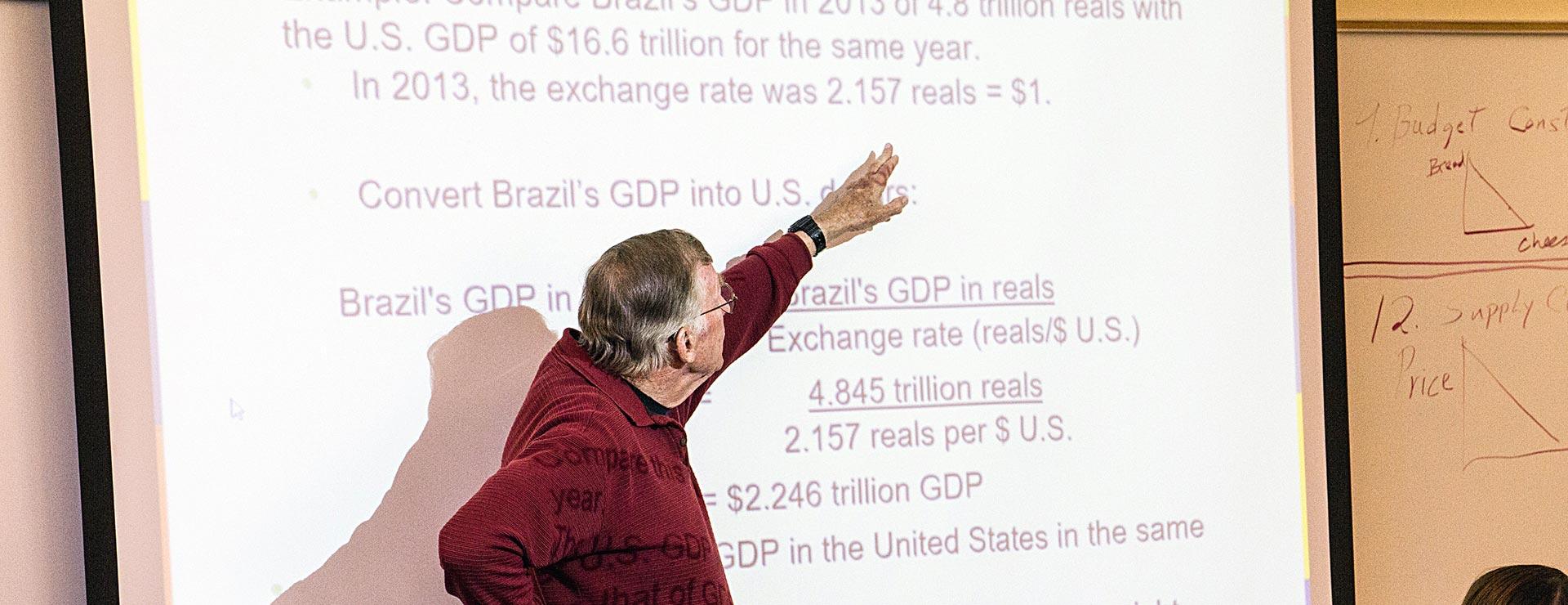 Economic instructor explaining how to convert international gross domestic product (GDP) into US dollars
